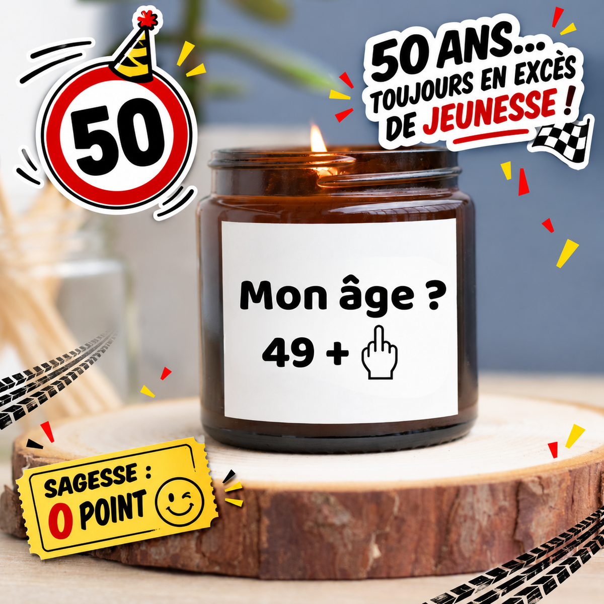 Bougie allumée en pot ambré avec le message Mon âge ? 49 + et un doigt d’honneur, entourée d’un panneau 50 et de confettis rouges et jaunes.