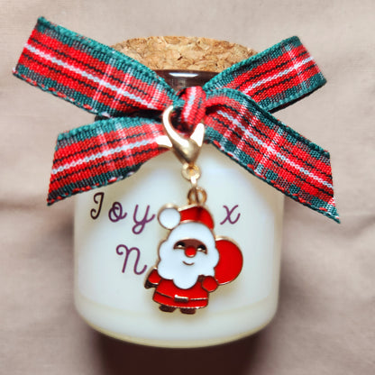 Bougie cadeau Joyeux Noël posée près d'un sapin illuminé dans un salon chaleureux