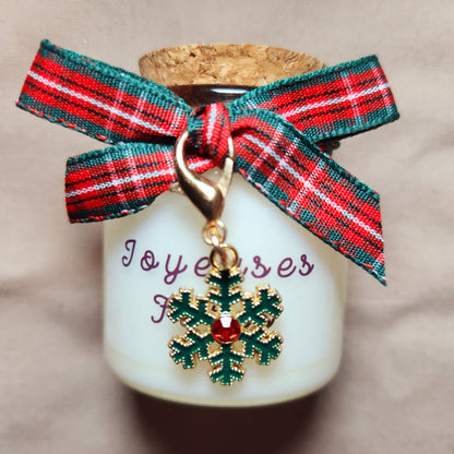 Bougie avec étiquette Joyeuses Fêtes disposée au centre d'une décoration de table de réveillon chaleureuse.