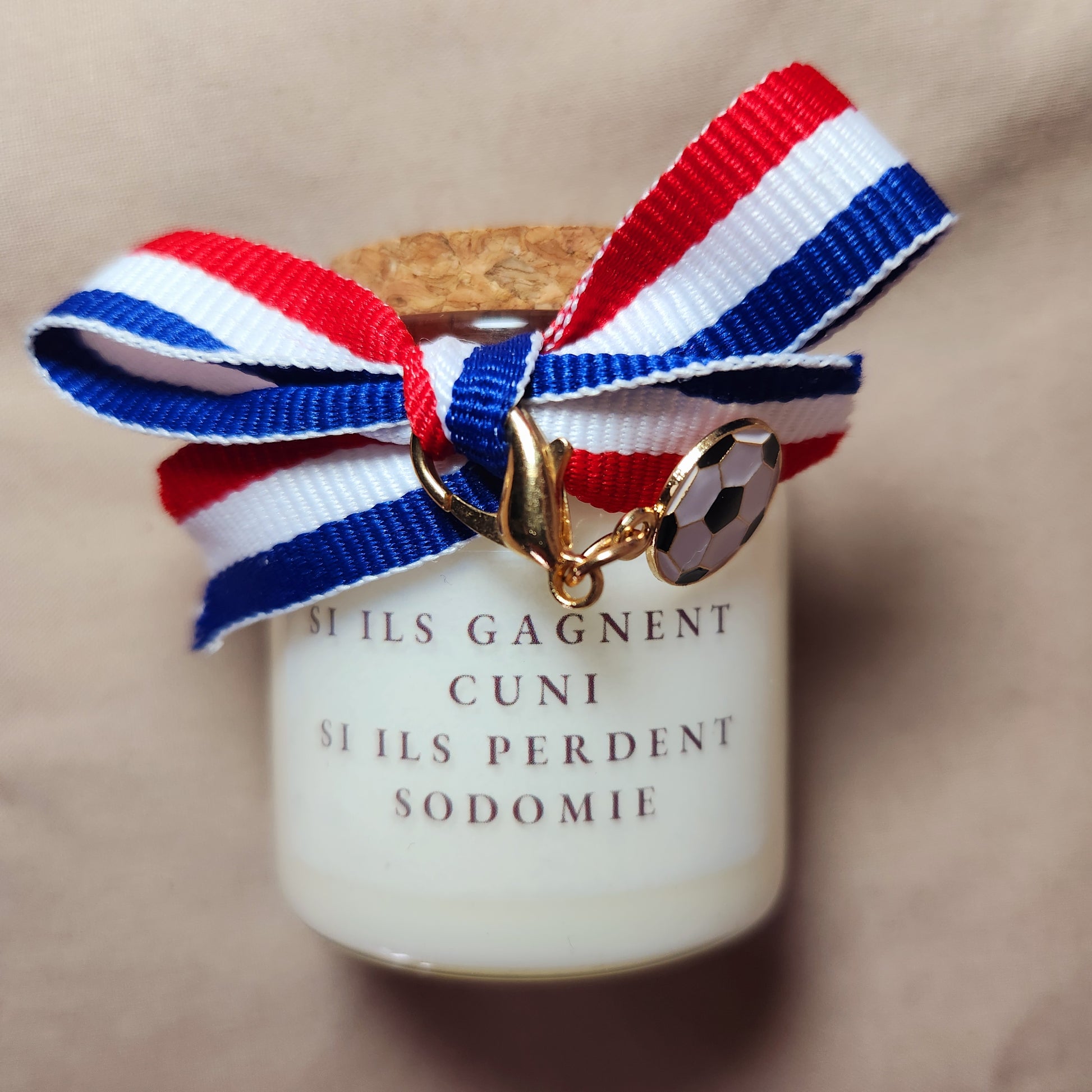 Bougie parfumée humoristique avec une inscription osée pour adulte sur le thème des paris de football en couple, allumée en intérieur.