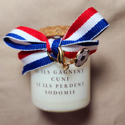 Bougie parfumée humoristique avec une inscription osée pour adulte sur le thème des paris de football en couple, allumée en intérieur.