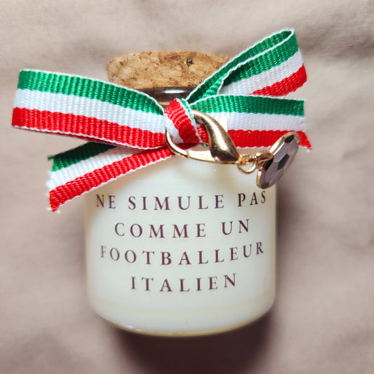Bougie parfumée humoristique avec l'inscription "Ne simule pas comme un joueur italien", décorée d'un ruban en tissu aux couleurs du drapeau italien (vert, blanc, rouge).
