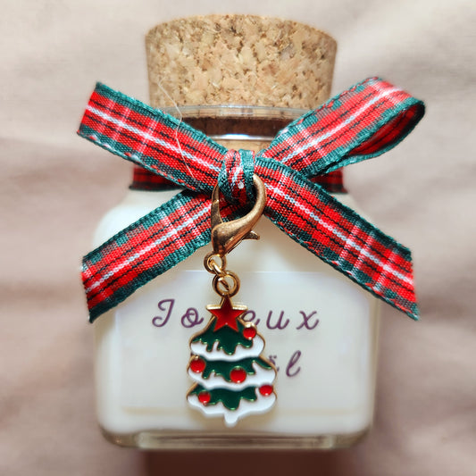 Bougie de fête blanche avec l'inscription Joyeux Noël imprimée sur l'étiquette.