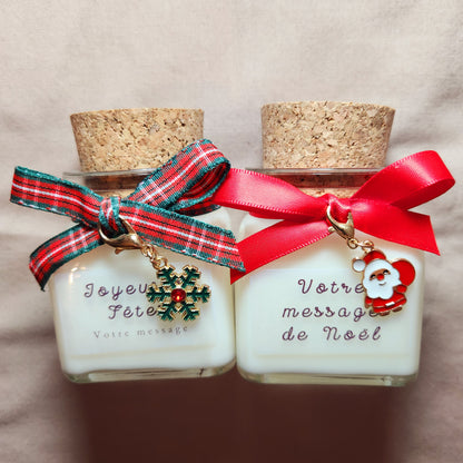 Bougie de Noël personnalisée avec un prénom écrit sur l'étiquette dans un décor de fête