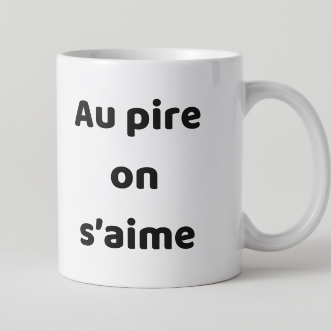 Mug en céramique blanche avec l'inscription humoristique Au pire on s'aime en texte noir, création originale pour couple.