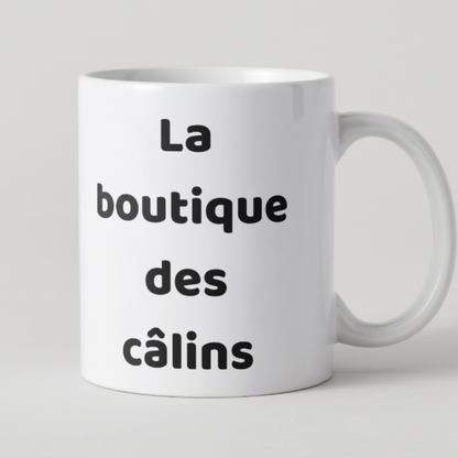 Mug blanc épuré avec l'inscription La boutique des câlins en lettres noires.