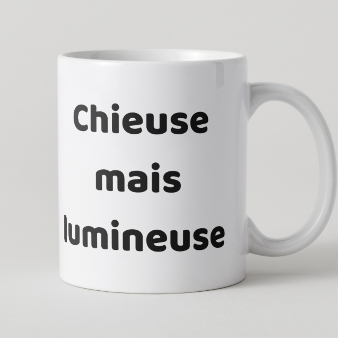 Mug en céramique blanche avec message humoristique "Chieuse mais lumineuse" écrit en noir, design minimaliste et élégant par Mamie Candle.