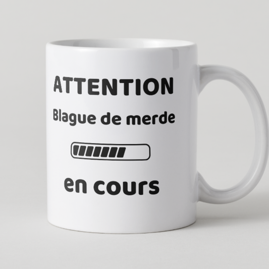 Mug blanc texte noir attention blague de merde en cours avec barre de chargement.