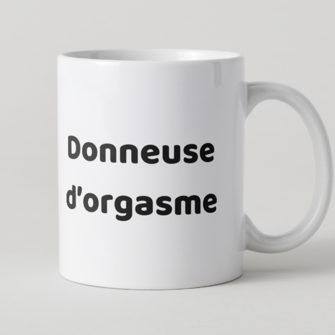 Mug blanc avec inscription humoristique et osée Donneuse d'orgasme en lettres noires.