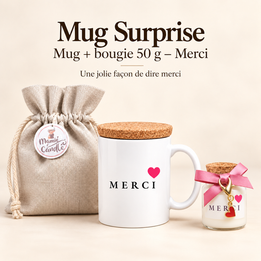 Mug blanc « Merci » avec cœur rose et couvercle en liège, accompagné d’une bougie de 50 g avec ruban rose et pendentif cœur, et d’un pochon Mamie Candle.