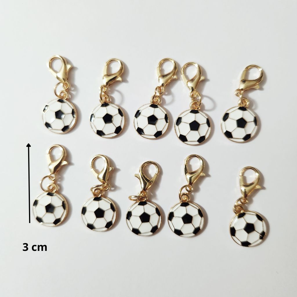 Petit pendentif en forme de ballon de football classique blanc et noir monté sur un fermoir mousqueton doré.