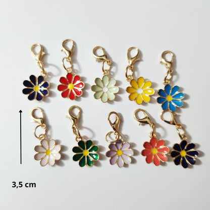 Assortiment de pendentifs en forme de fleurs de marguerites colorées en émail avec contours dorés et fermoirs mousquetons, d'après le fichier fleurs
