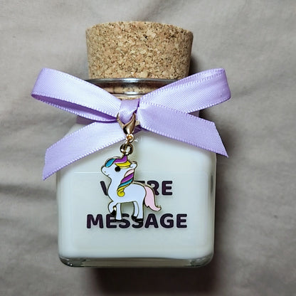 Bougie parfumée licorne grand format posée à côté d'une décoration d'anniversaire je suis une licorne