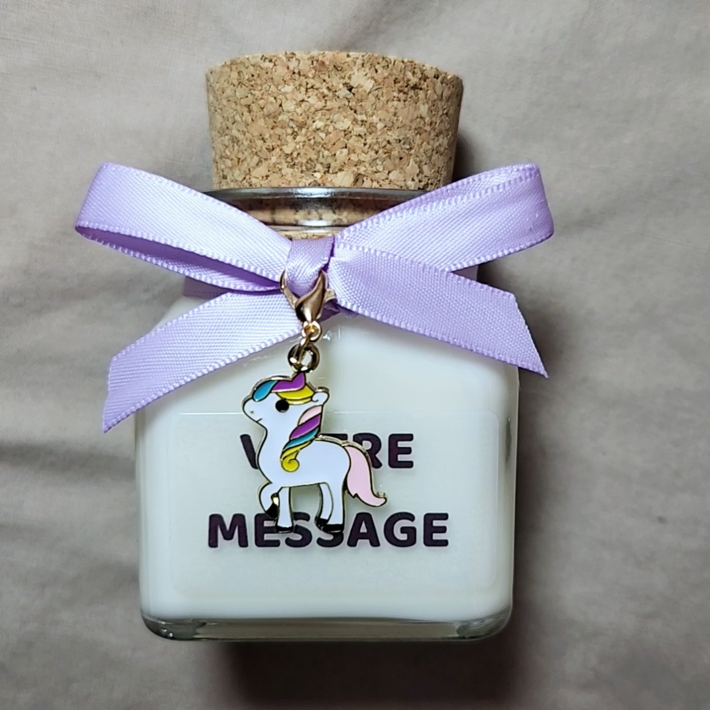 Bougie parfumée licorne grand format posée à côté d'une décoration d'anniversaire je suis une licorne