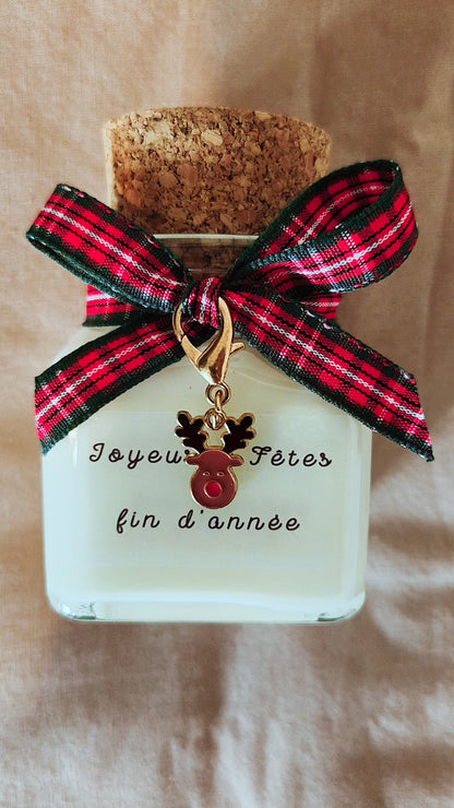 Bougie Joyeuses fêtes de fin d'année posée sur une table de Noël festive.