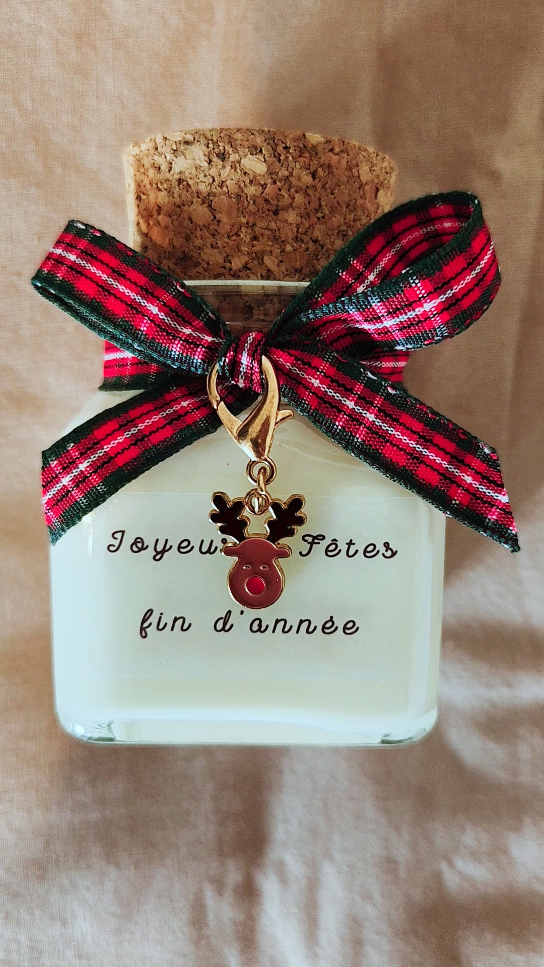 Bougie Joyeuses fêtes de fin d'année posée sur une table de Noël festive.