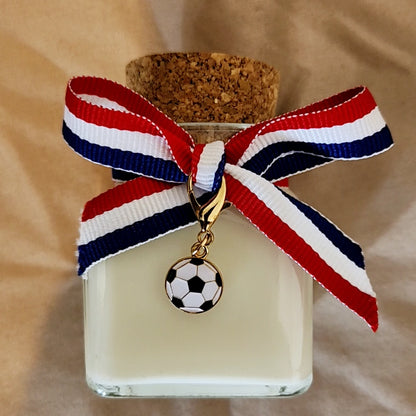 Vidéo de présentation de la nouvelle collection de bougies parfumées sur le thème du football, montrant plusieurs modèles artisanaux aux messages humoristiques, de supporters et de couple défilant dans un décor chaleureux de salon.