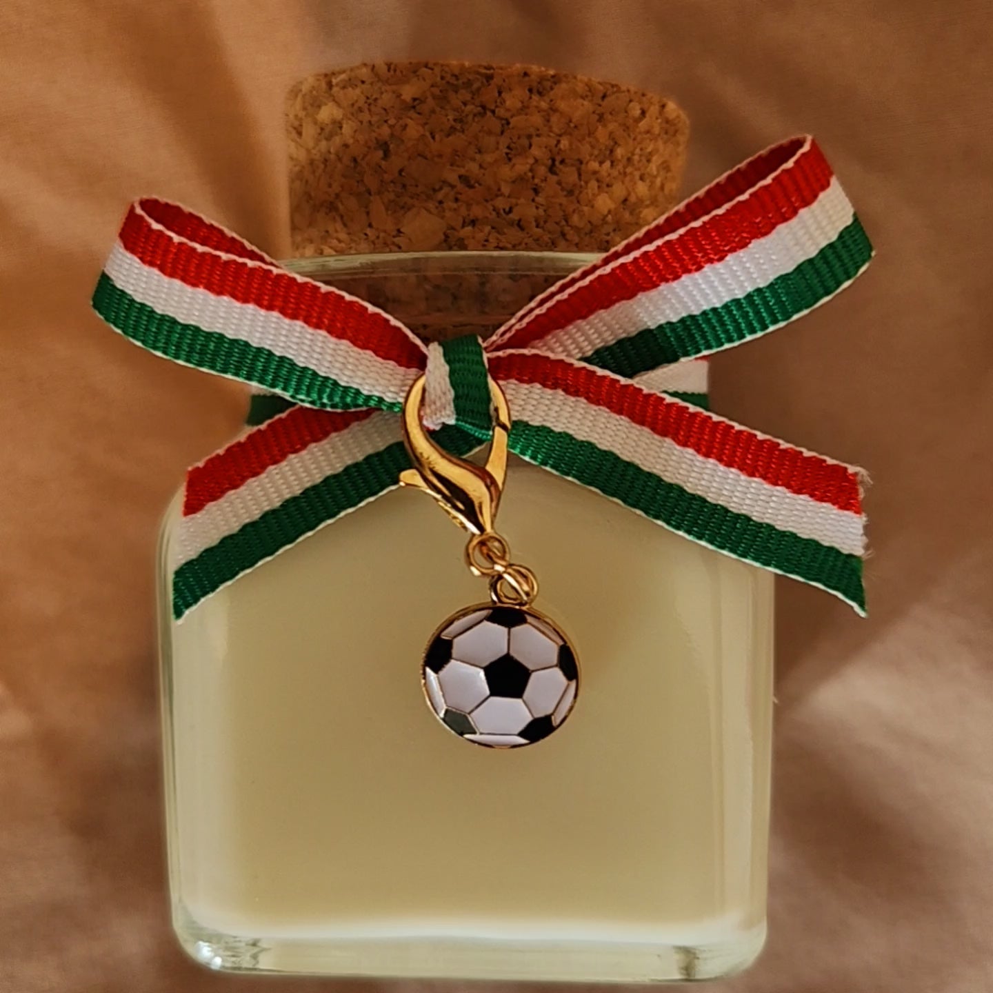 Bougie parfumée humoristique avec l'inscription Ne simule pas comme un footballeur italien, décorée d'un élégant ruban en tissu aux couleurs du drapeau de l'Italie.mamiecandle