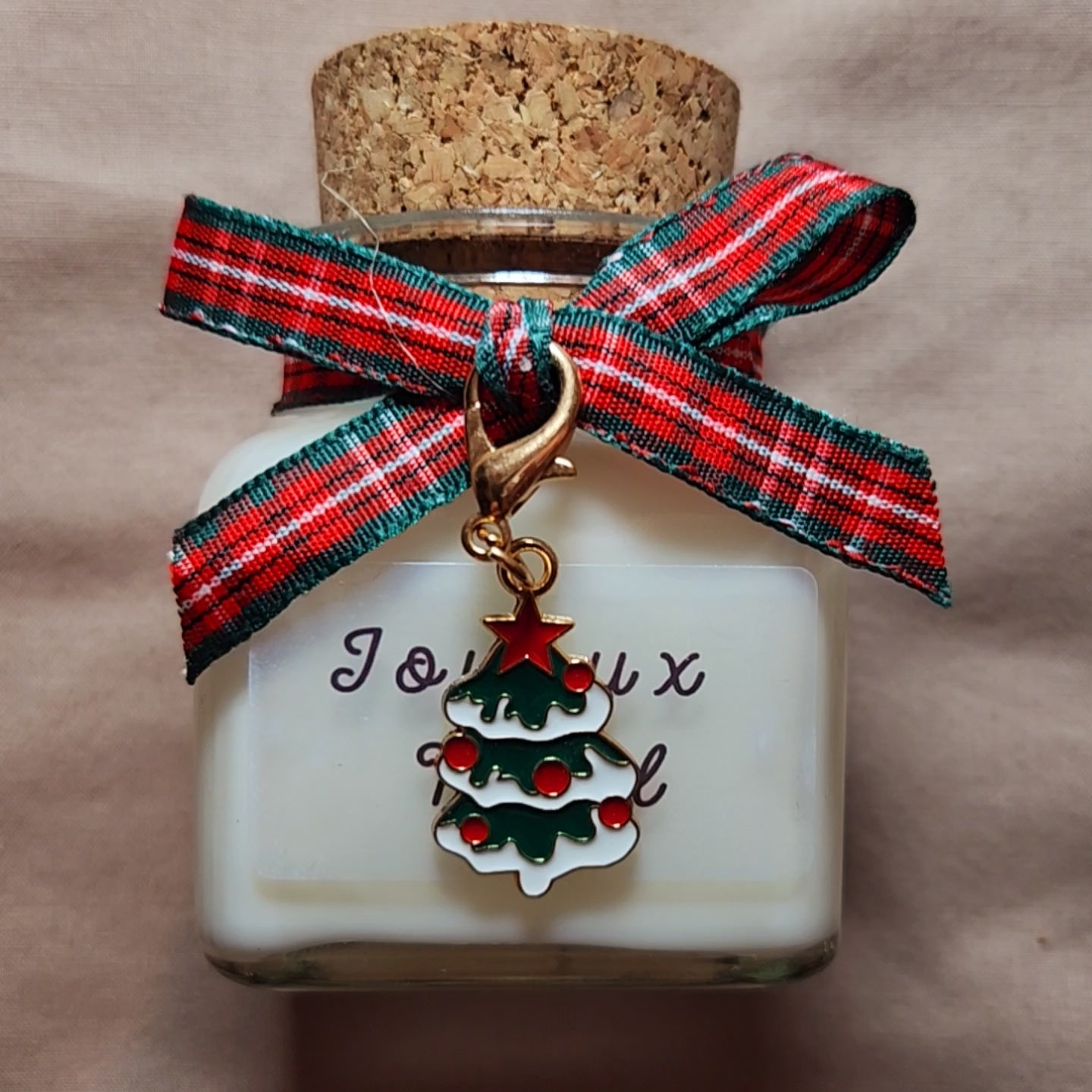 Vidéo de présentation de la bougie Joyeux Noël allumée à côté du sapin.