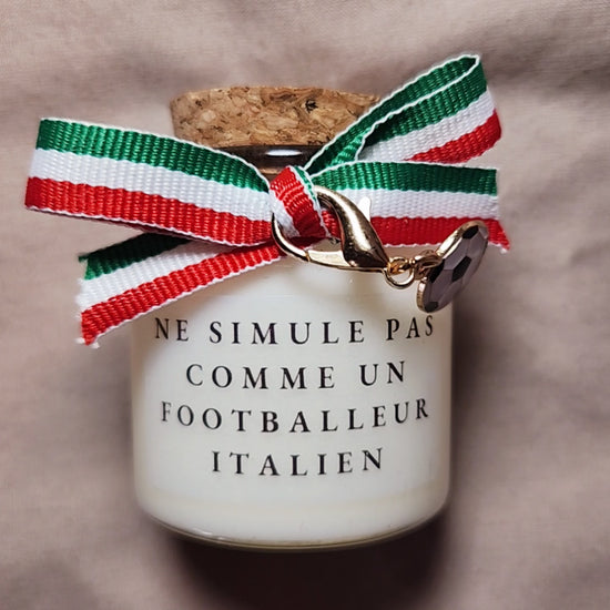 Bougie parfumée humoristique avec l'inscription "Ne simule pas comme un joueur italien", décorée d'un ruban en tissu aux couleurs du drapeau italien (vert, blanc, rouge). mamiecandle