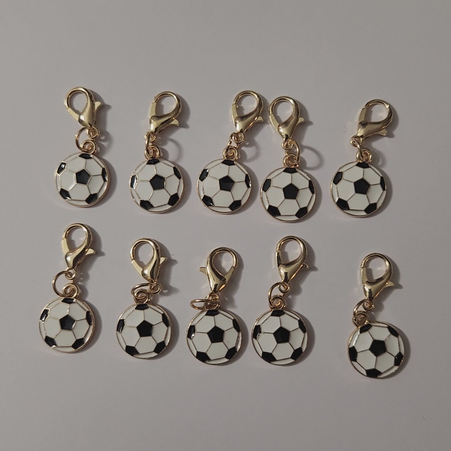 Petit pendentif en forme de ballon de football classique blanc et noir monté sur un fermoir mousqueton doré.mamiecandle