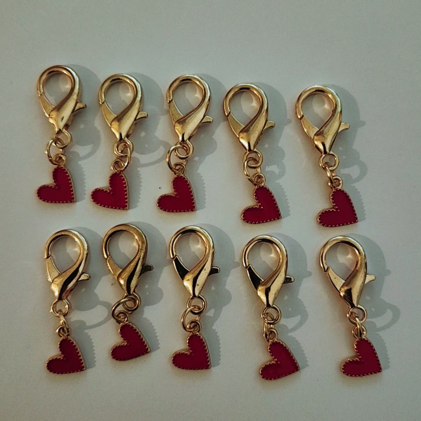 Pendentif en forme de larme dorée abritant un magnifique cœur rouge vif suspendu à un mousqueton.mamiecandle